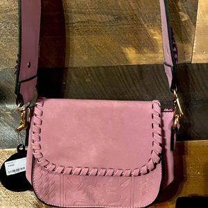 This is a Kiss Me Couture Purse. It is a soft material and is pink. Really cute.